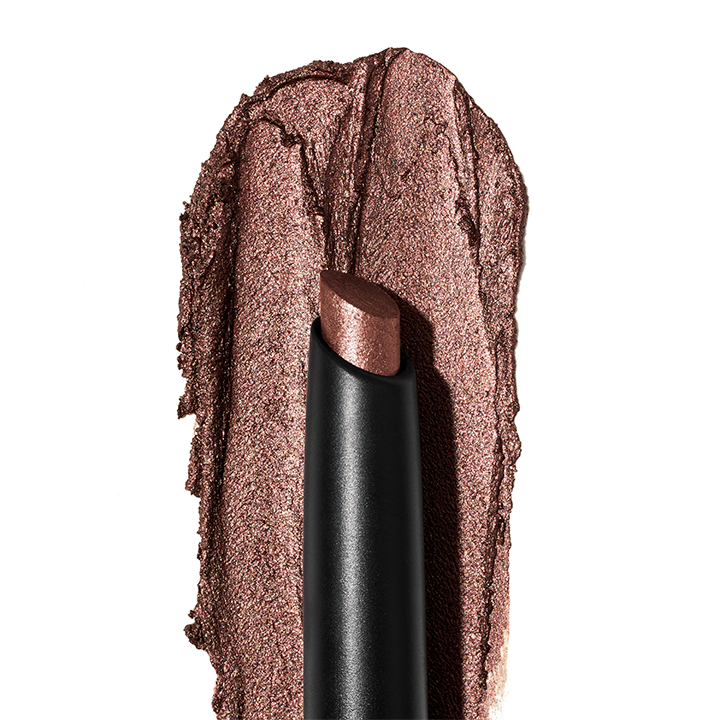 Mary Kay Shimmer Eye Shadow Stick with a texture rub in the background